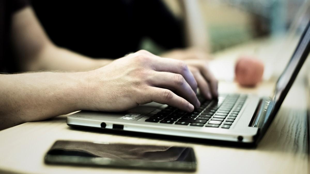 Hænder taster på et tastatur. 